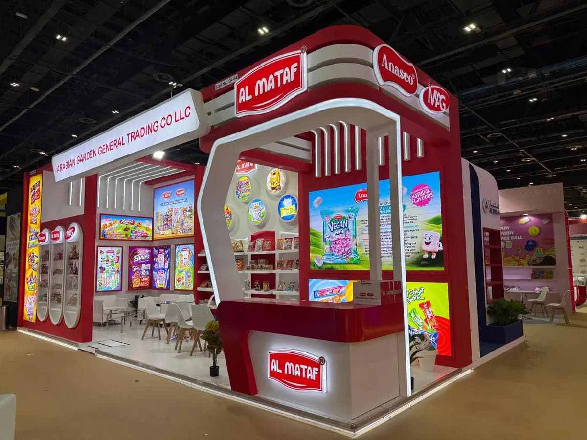 Al Mataf red and white corner stand with arched entrance and backlit product walls at ISM Middle East 2025