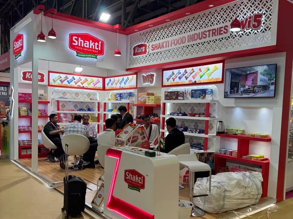 Shakti Food Industries white stand with lattice fascia, red shelving and meeting tables at ISM Middle East 2025