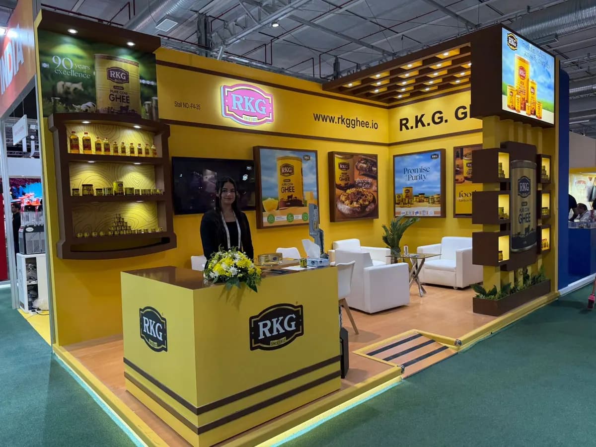 RKG Ghee yellow corner stand with wooden display shelves and reception counter at The Saudi Food Show 2025